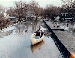 Man floating in his boat in the water on the roof